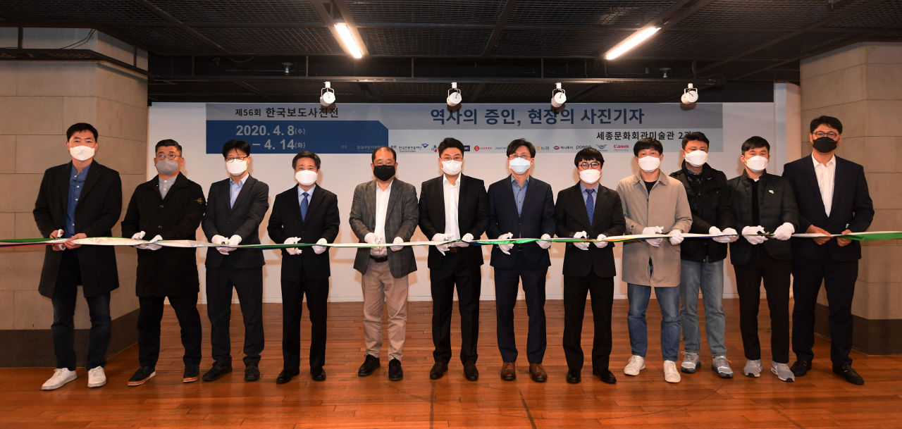 8일 '제56회 한국보도사진전'이 세종문화회관 미술관에서 열린 가운데 안주영 한국사진기자협회 회장(왼쪽 다섯번째)과 윤도한 청와대 국민소통수석(왼쪽 네번째)을 비롯한 수상자와 내외빈이 기념촬영을 하고 있다. [사진공동취재단]