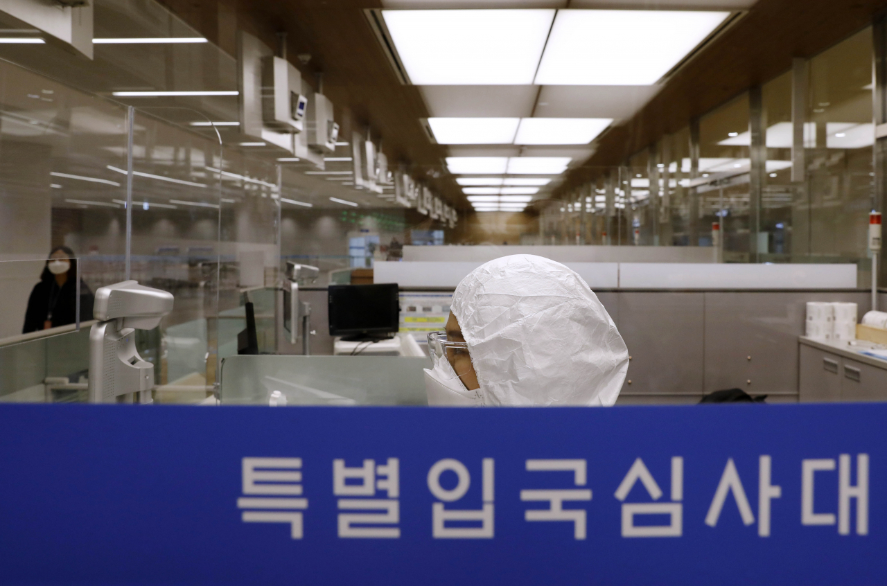 인천공항 출입국 외국인청 입국심사관이 8일 오후 인천국제공항 제2터미널 유증상자 전용 입국심사대에서 방진복을 입은 채 업무를 준비하고 있다. [연합]