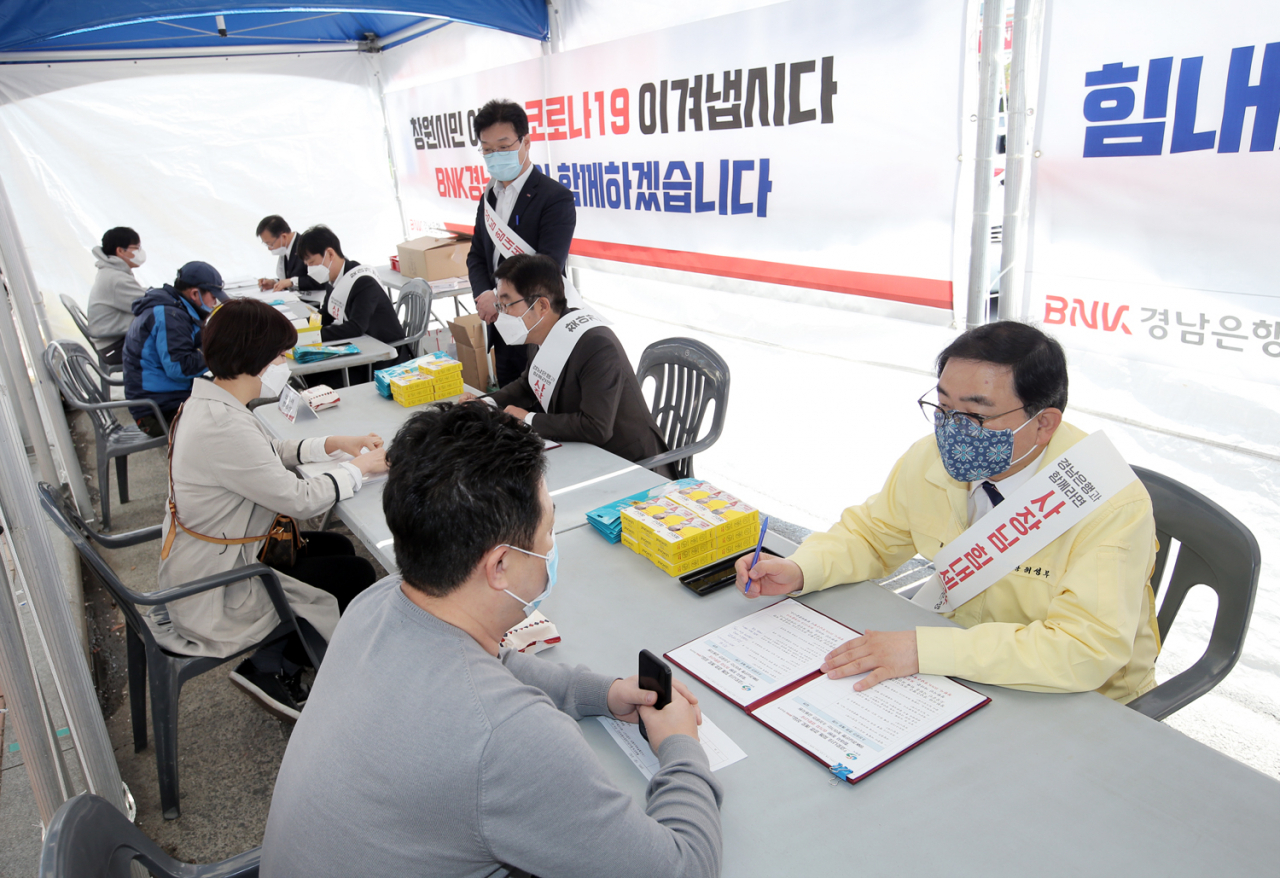 BNK경남은행 황윤철 은행장과 창원시 허성무 시장이 영세 소상공인들의 애로사항을 청취하고 코로나19 관련 대출을 안내하고 있다.