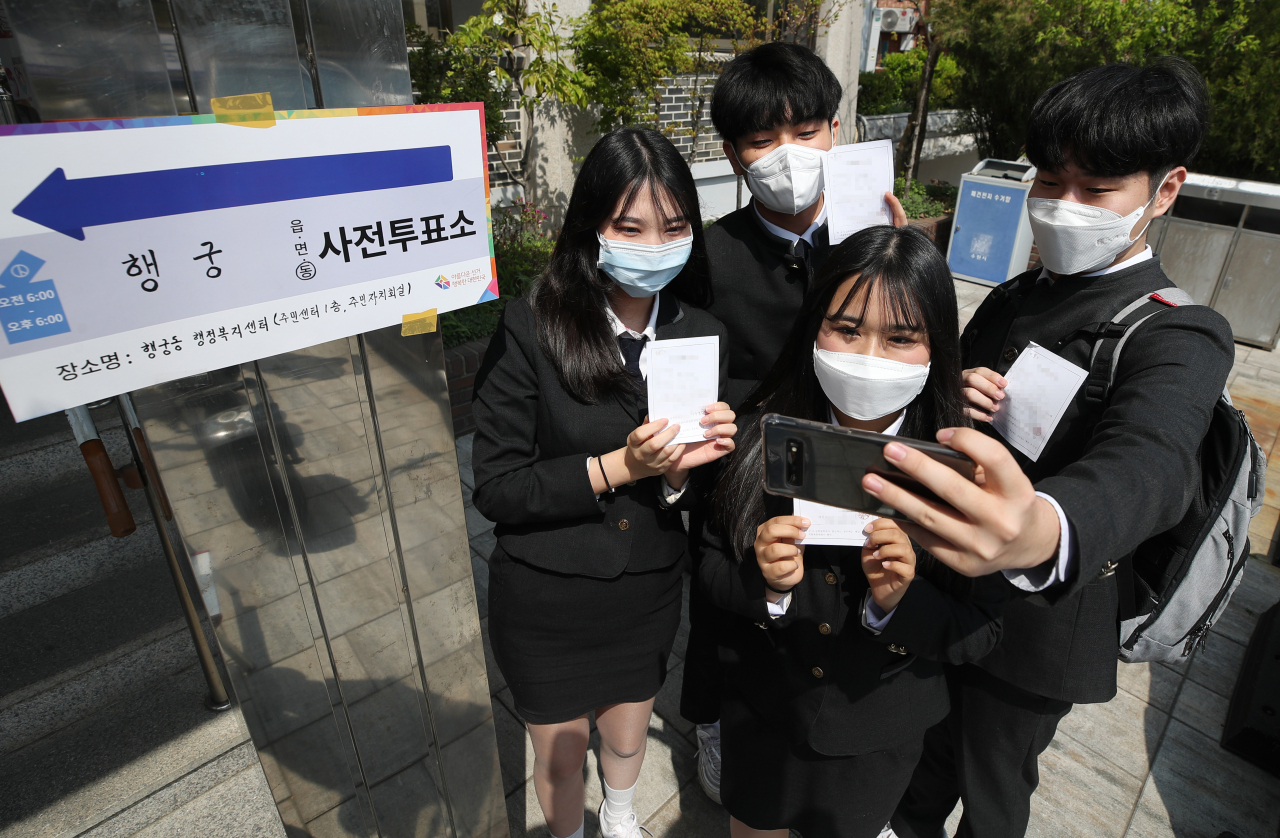 제21대 국회의원선거 사전투표 첫날인 10일 오후 경기도 수원시 팔달구 행궁동 행정복지센터에 설치된 사전투표소에서 선거연령 하향조정으로 처음으로 투표권을 행사한 삼일공업고등학교 학생들이 투표확인증을 들고 기념촬영을 하고 있다. 연합뉴스