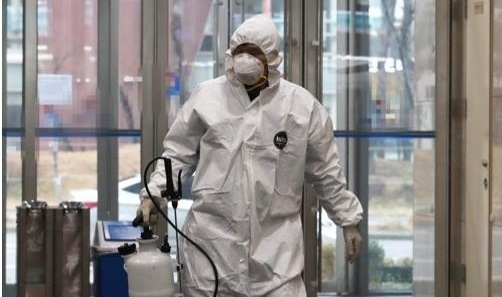A health worker wearing a protective suit enters the Ministry of Personnel Management in Sejong City, 130 kilometers south of Seoul, on Feb. 28, 2020, after an employee tested positive for the novel coronavirus. (Yonhap)