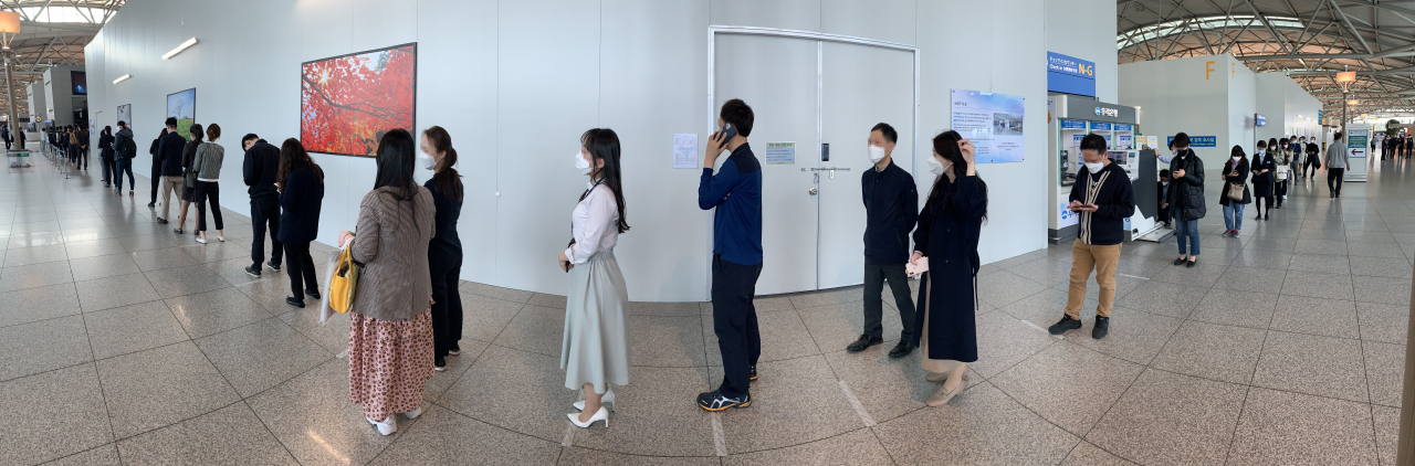 제21대 국회의원 선거 사전투표 첫날인 지난 10일 인천국제공항 제2터미널 출국장에 설치된 사전투표소에서 유권자들이 신종 코로나바이러스 감염증(코로나19) 예방을 위한 사회적 거리두기를 하며 줄을 서고 있다. [연합]