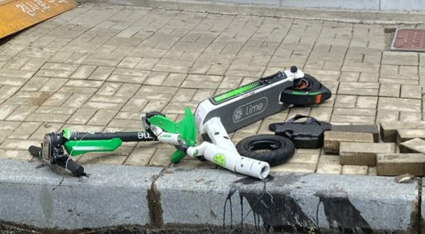 지난 12일 새벽 부산 해운대구의 한 도로에서 차량과 충돌해 박살난 ‘라임’ 공유 전동 킥보드. 이 사고로 킥보드 운전자가 숨졌다. [연합]