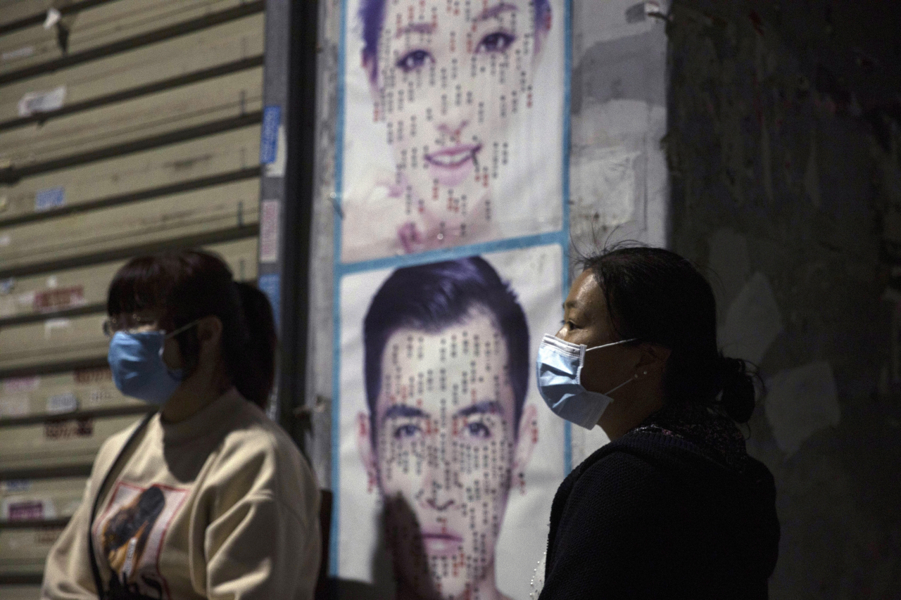 중국 후베이성 우한시 거리에서 마스크를 쓰고 있는 행인들의 모습 [AP]