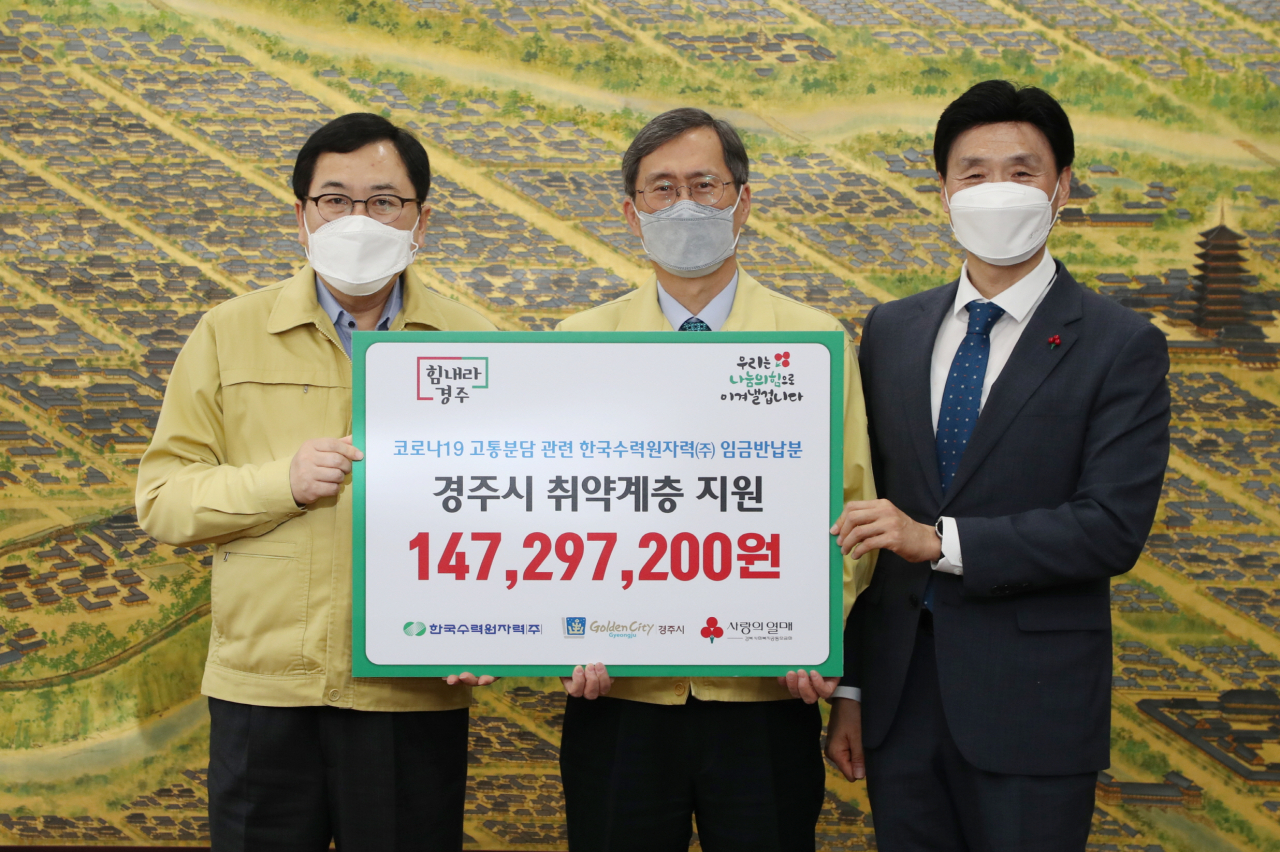 정재훈(가운데) 한국수력원자력 사장이 13일 코로나19 분담 차원에서 본사 부장급 이상 간부들이 반납한 임금 1억 4000여만원을 경주시청에 기부한 후 기념촬영을 하고 있다. ［한국수력원자력 제공］