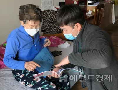 치매노인에게 인지책자를 보여주고 있다. [도봉구 제공]