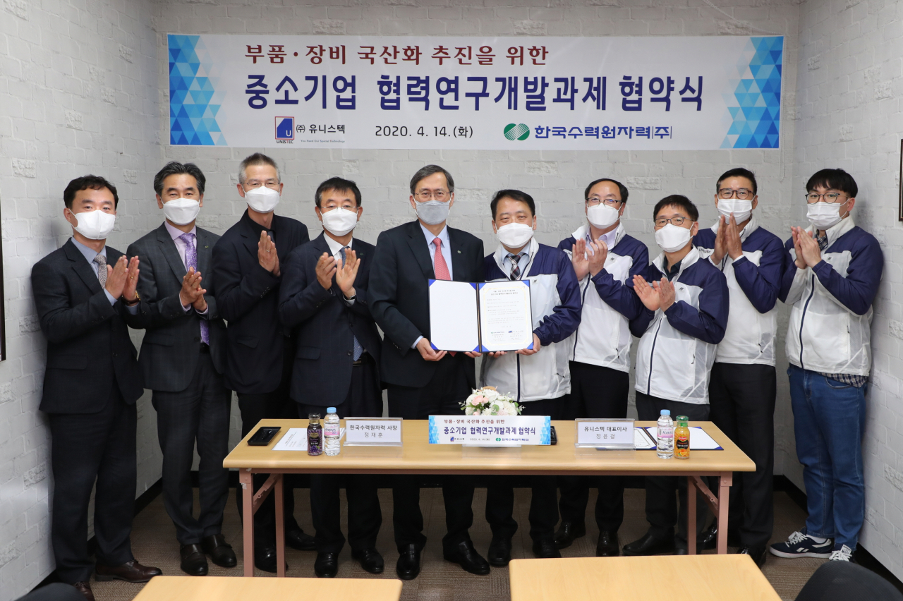 정재훈(왼쪽 다섯번째) 한국수력원자력 사장이 14일 부산 강서구 중소기업인 ㈜유니스텍과 ‘격납건물 내부 철골 내진간극 측정용 장비 국산화 개발’을 위한 협약을 체결한 후 기념촬영하고 있다. ［한국수력원자력 제공］