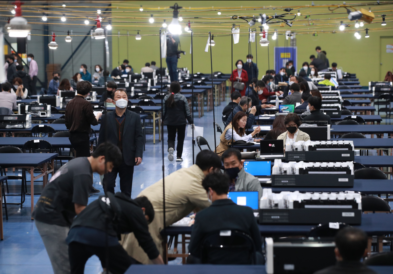 Election officials prepare for ballot counting. Yonhap