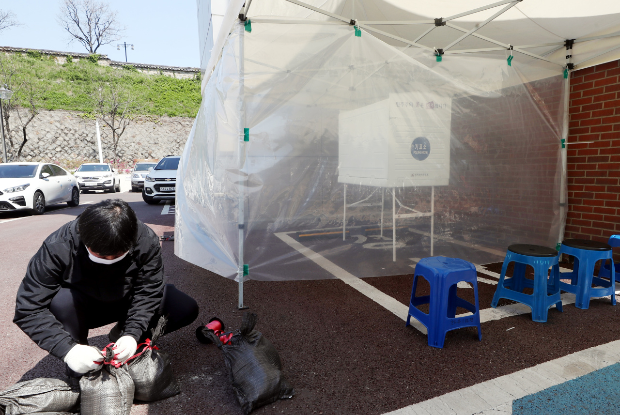 Election officials set up a special polling booth outside a polling station in Incheon, exclusively for voters who are quarantined for possible COVID-19 infection on Tuesday, prior to Wednesday’s parliamentary elections. (Yonhap)