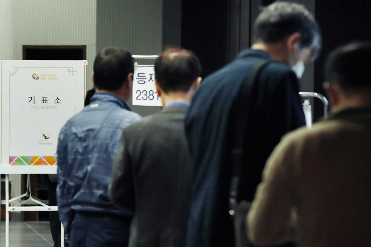 Voters wait in line at a polling station in Seoul on Wednesday. Yonhap