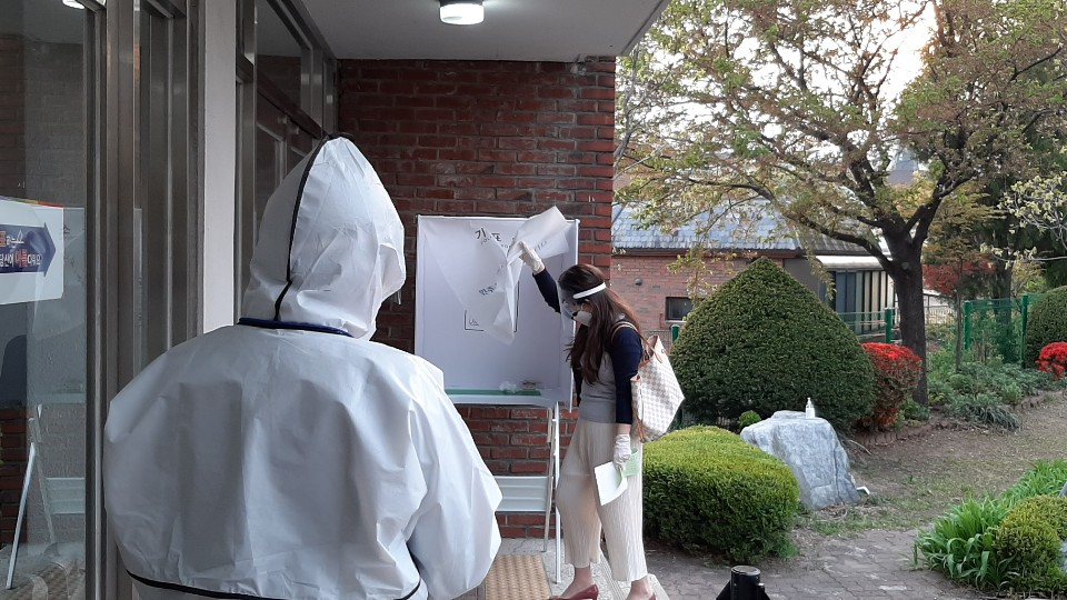 15일 한 자가격리자가 투표를 하고 있는 모습.