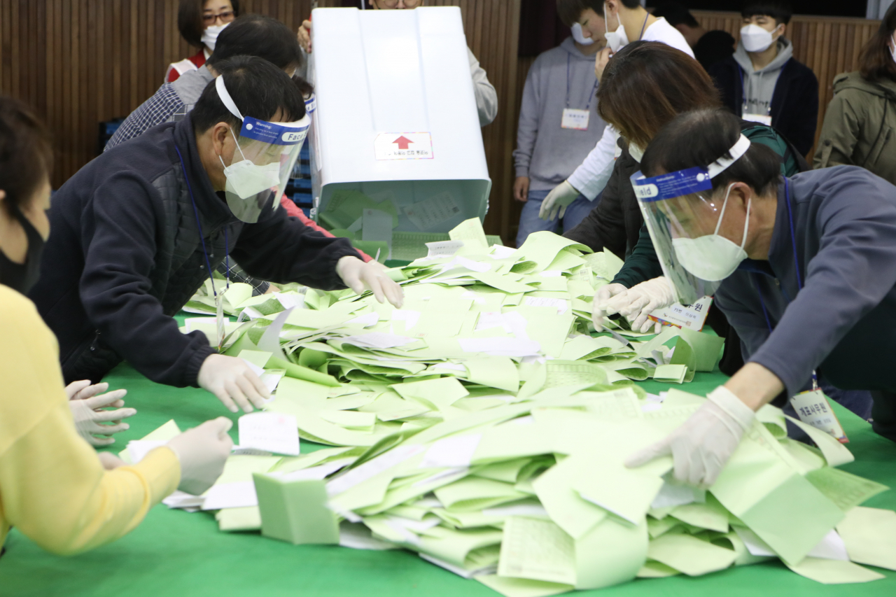 제21대 국회의원의 투표가 마감된 15일 오후 부산 동래중학교체육관에 마련된 동래구개표소에서 개표 사무원들이 투표용지 개표작업을 하고 있다. [연합]
