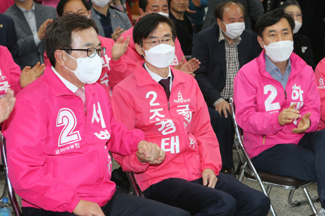 15일 오후 부산 수영구 미래통합당 부산시당사에서 방송 3사 출구조사 결과 우세가 점쳐지자 서병수, 조경태 부산선대위공동선대위원장과 하태경 부산선대위본부장이 손을 맞잡으며 안도하고 있다. [연합]