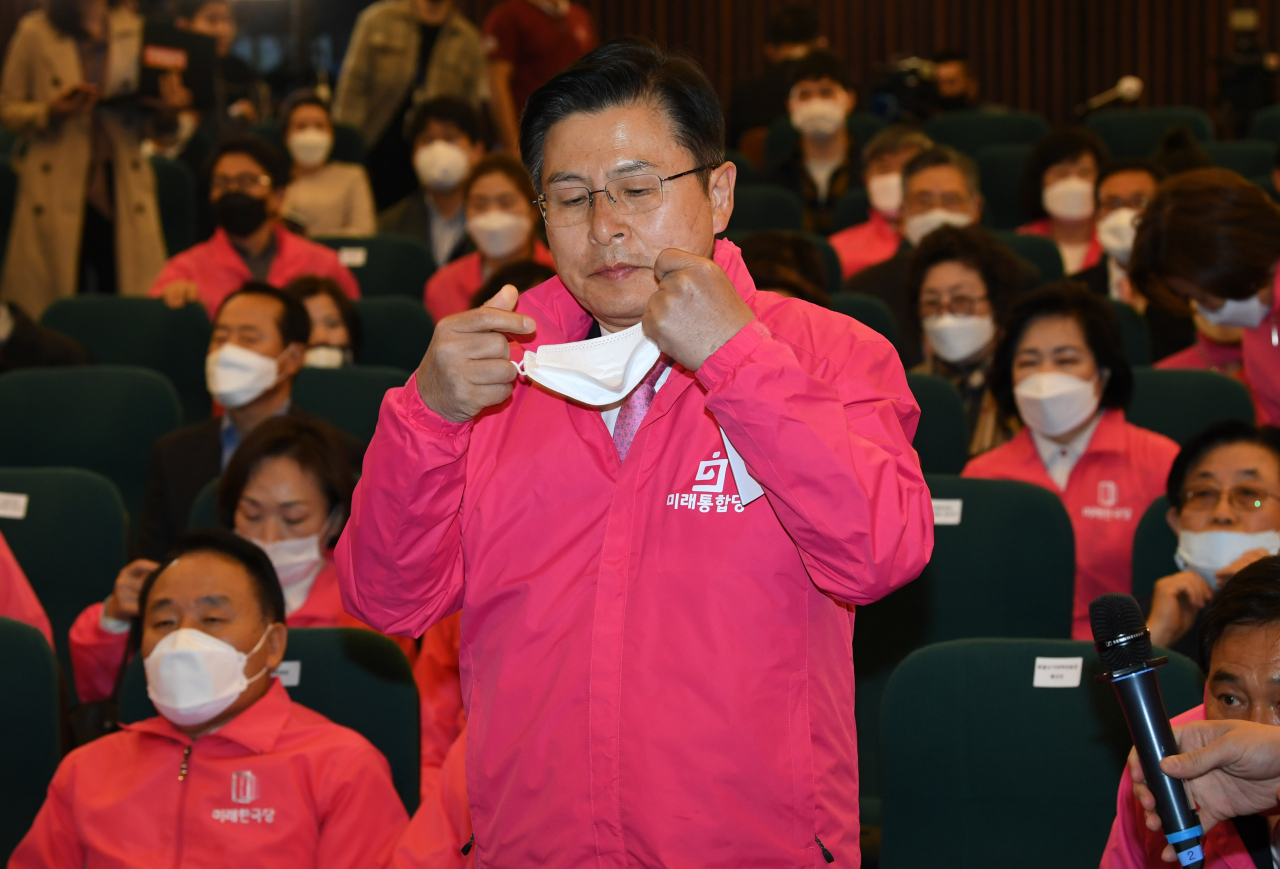 황교안 미래통합당 대표가 제21대 총선일인 15일 국회도서관 강당에 마련된 개표상황실에서 방송사 출구조사 결과 발표가 끝난 뒤 취재진에게 소감을 말하기 위해 마스크를 벗고 있다. [연합]