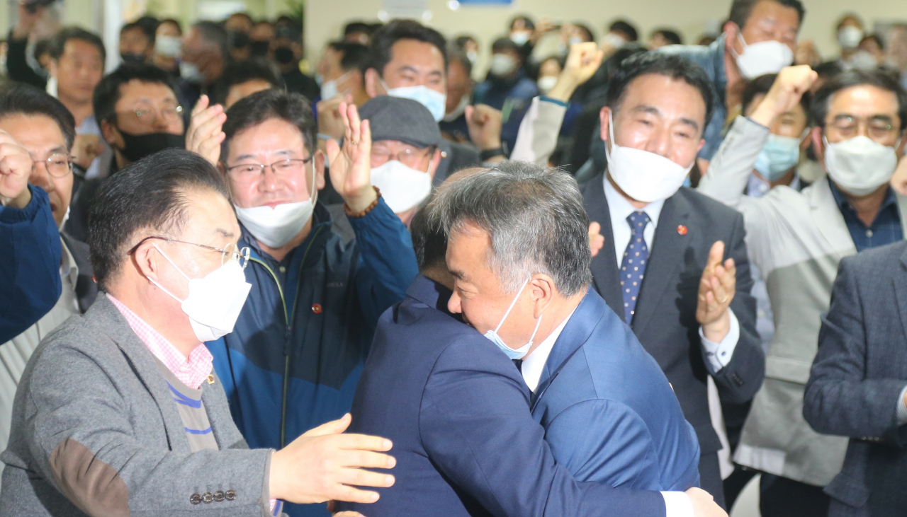 15일 총선 투표 종료 후 방송사 출구조사에서 승리가 예측된 제주시갑 더불어민주당 송재호 후보(앞줄 맨 오른쪽)이 강창일 민주당 국회의원(가운데)과 포옹을 하고 있다. [연합]
