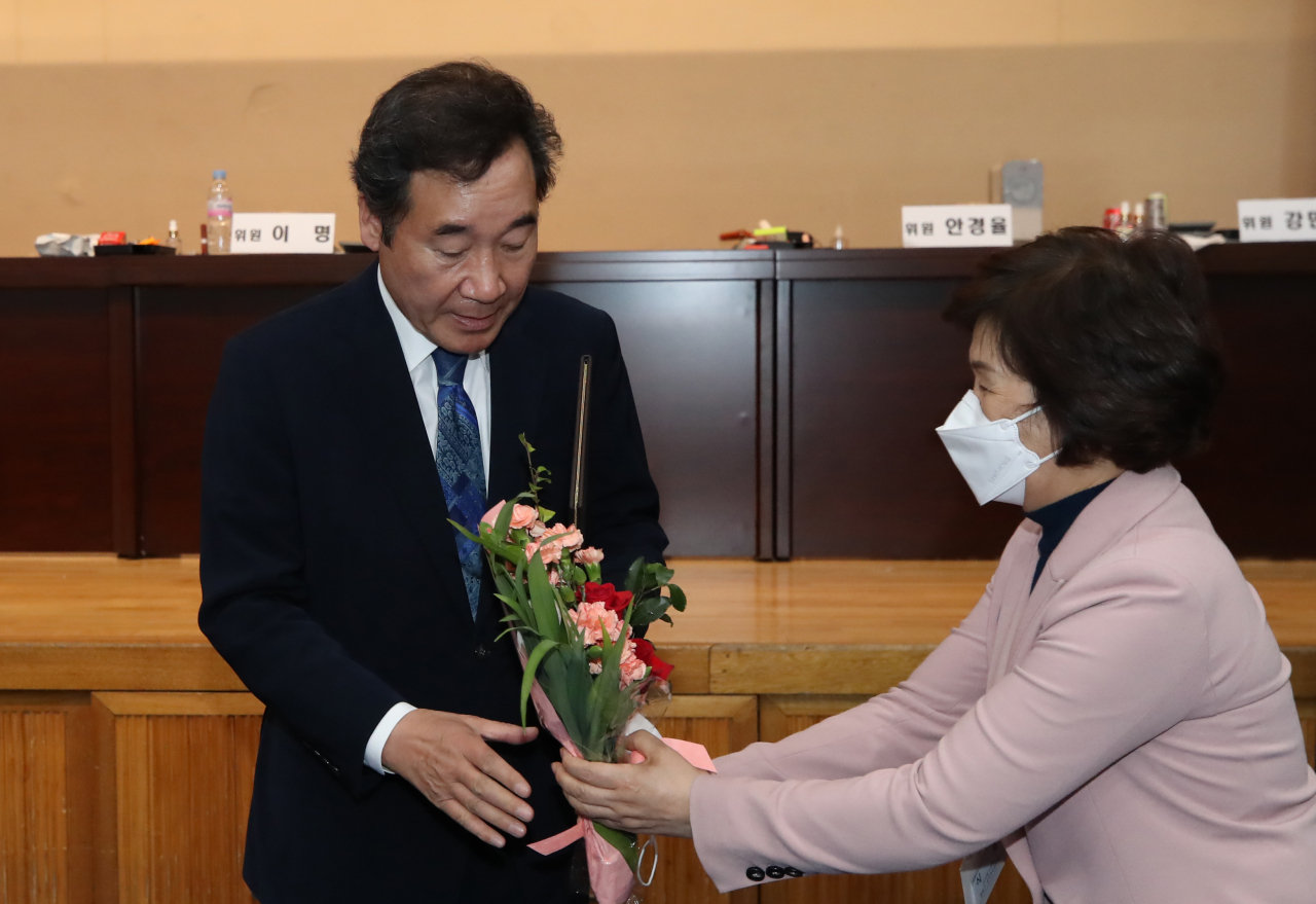 21대 총선 서울 종로에서 당선된 이낙연 더불어민주당 코로나19국난극복대책위원장(왼쪽)이 16일 새벽 개표소가 마련된 서울 종로구 경복고등학교에서 열린 당선증 수여식에서 꽃다발을 받고 있다. [연합]