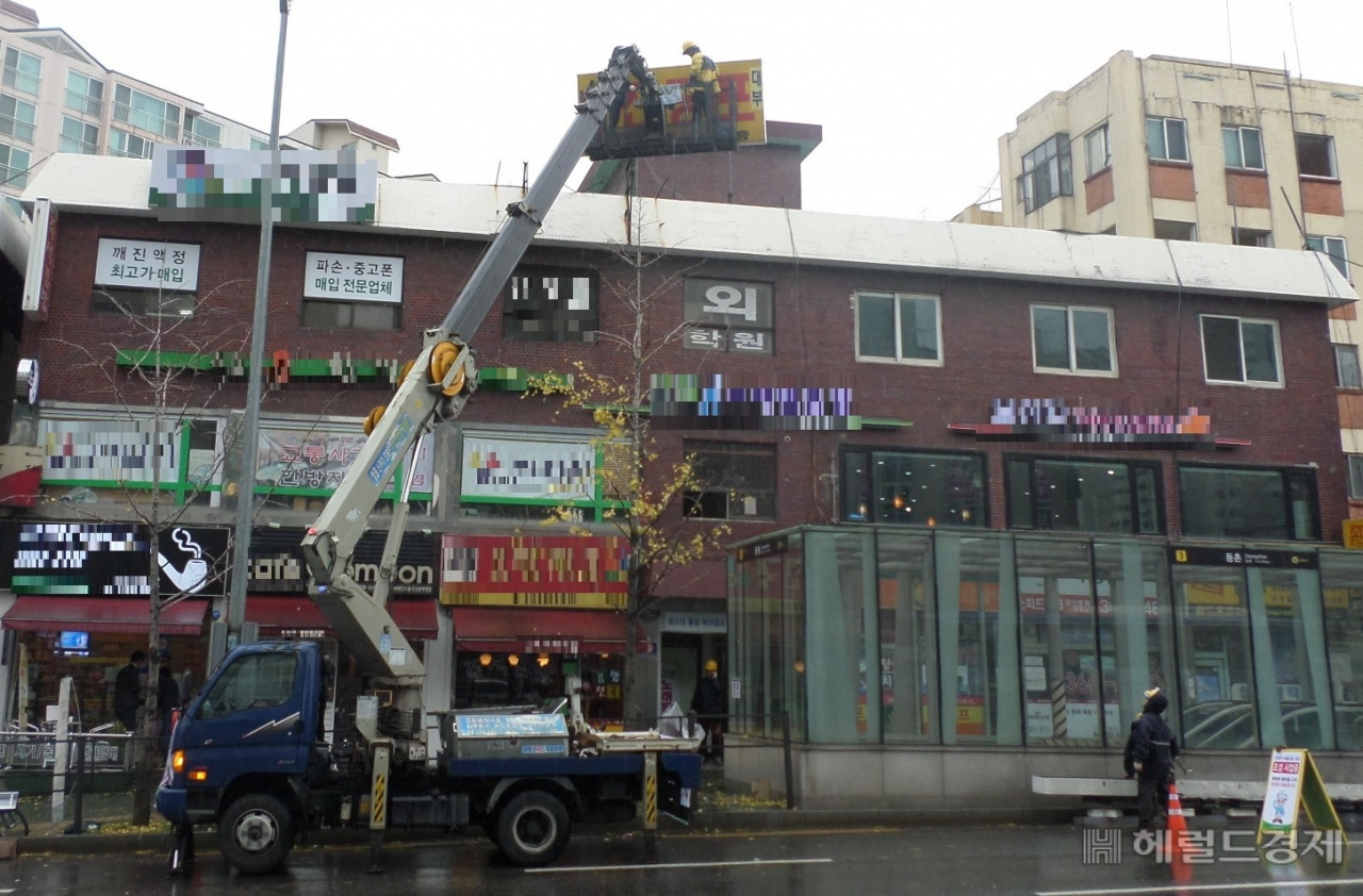 강서구청 관계자들이 무연고 간판을 철거하고 있다. [강서구]