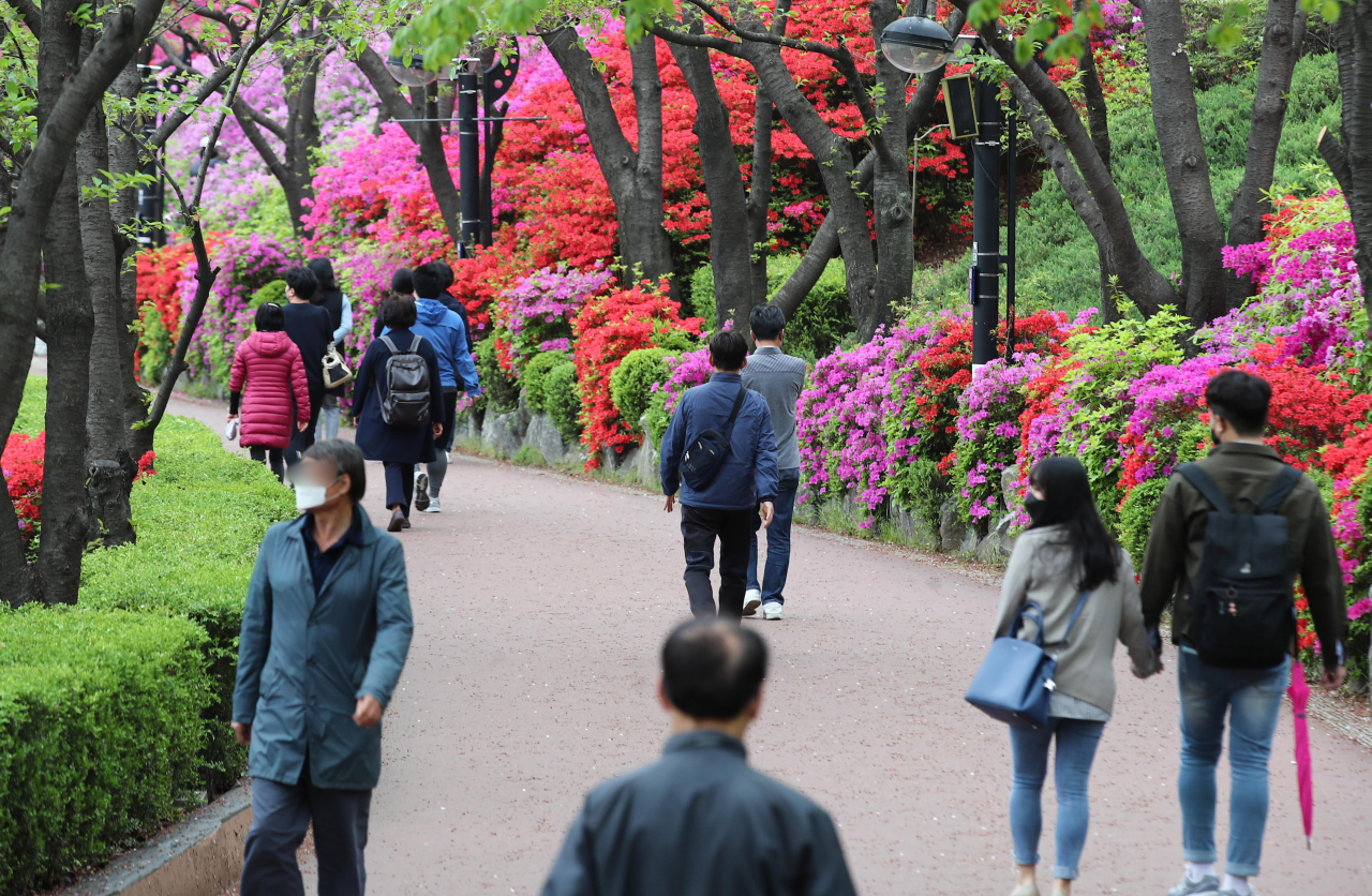 19일 오후 서울 송파구 석촌호수에서 시민들이 산책하고 있다. [연합]