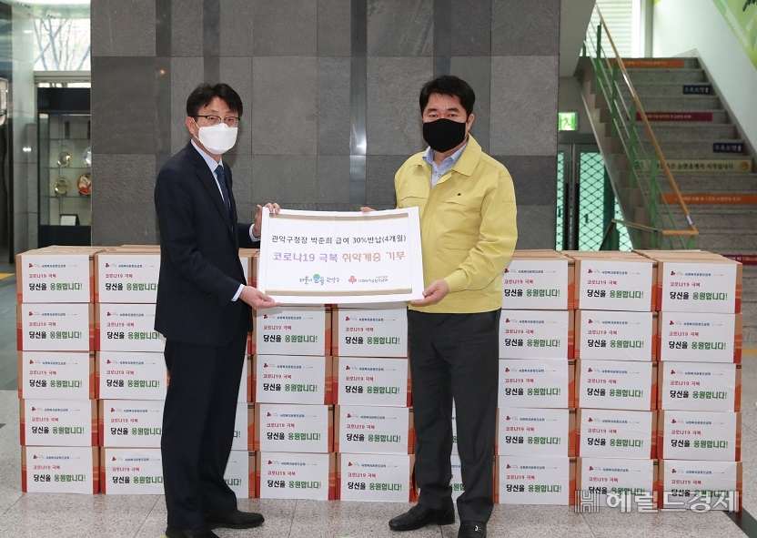 박준희(오른쪽) 관악구청장이 자신이 반납한 급여로 구입한 위문품을 구청 1층에서 전달하고 있다. [관악구]