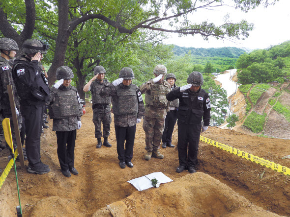 군 장병들이 화살머리고지 일대서 발굴된 전사자에 헌화하고 있다. [국방부 제공]