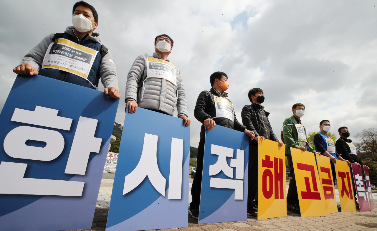 20일 오전 청와대 분수대 앞에서 열린 '항공·공항 한시적 해고금지 촉구 현장실천단' 발족 기자회견에서 참석자들이 손팻말을 들고 있다. [연합]