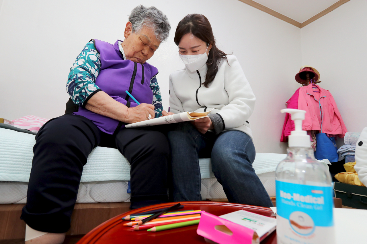 지난 14일 성동구치매안심센터 직원이 코로나19 사태로 치매안심 지원센터를 찾아오지 못하는 맞춤형 사례관리자 어르신을 찾아가 색칠 프로그램을 진행하고 있다. [성동구 제공]