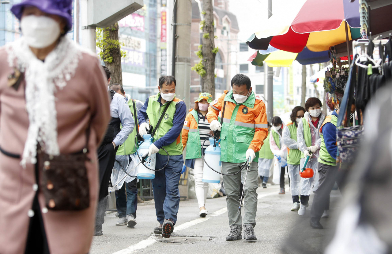 20일 오전 광주 북구 말바우시장 인근 상점가에서 광주 북구청 안전총괄과 직원들과 지역자율방재단원들이 코로나19 지역사회 확산 예방을 위한 방역 소독을 하고 있다. 연합뉴스