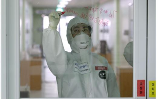 한 간호장교가 코로나19 현장에서 유리창에 메시지를 전하고 있다.[사진=국방부]