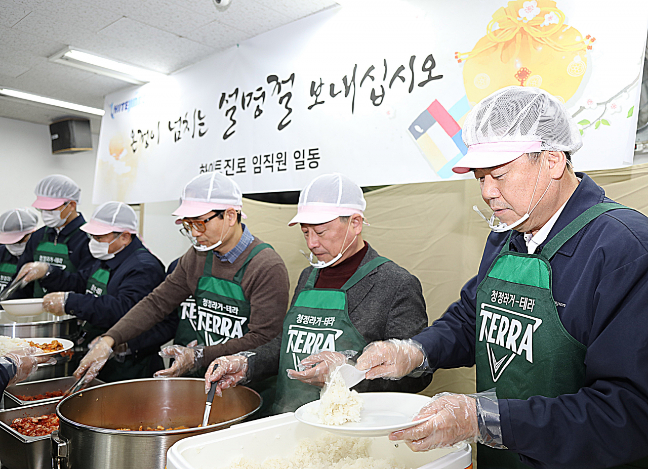김인규 하이트진로 사장(오른쪽에서 첫 번째)이 최근 서울역 인근 무료급식소 '따스한채움터'에서 임직원들과 함께 노숙인들에게 배식하고 있다. [사진제공=하이트진로]