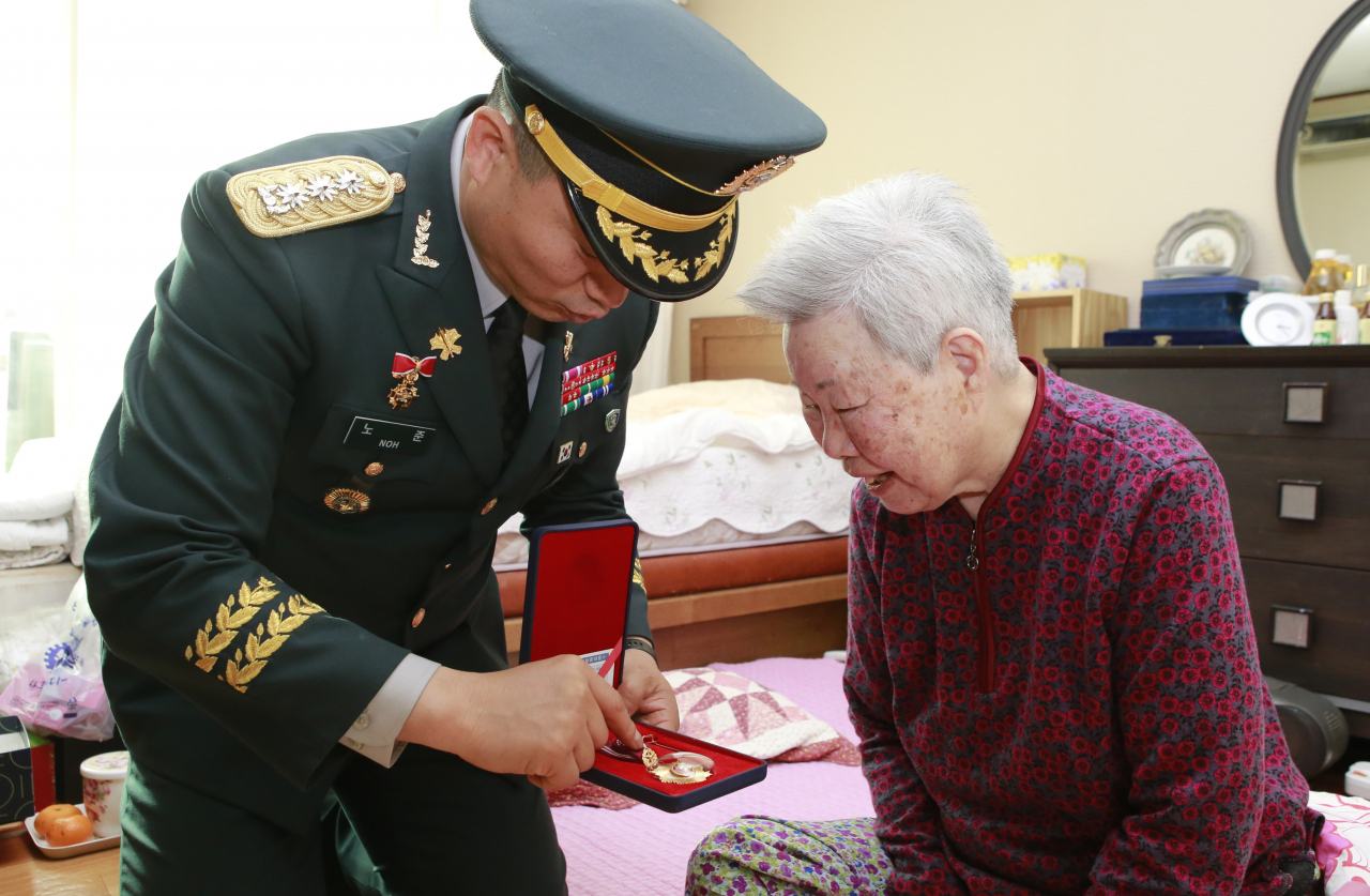 국방부가 23일 '6·25전쟁 무공훈장 수여 등에 관한 법률' 제정 1주년을 맞아 '우주선 프로젝트'를 추진하여 무공훈장 주인공 찾기 캠페인을 더욱 확대한다. 사진은 육군 23사단 57연대장 노준 대령이 지난해 12월 4일, 권순희 예비역 소령 자택을 방문하여 훈장을 수여하고 있는 모습.[연합]