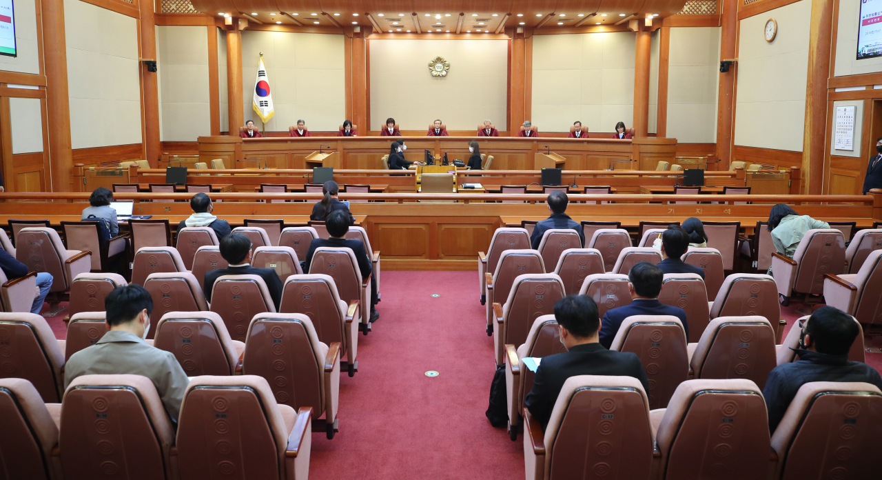 23일 오후 서울 종로구 헌법재판소에서 선고 장면을 보기 위한 방청객들이 서로 떨어져서 자리에 앉아 있다. [연합]