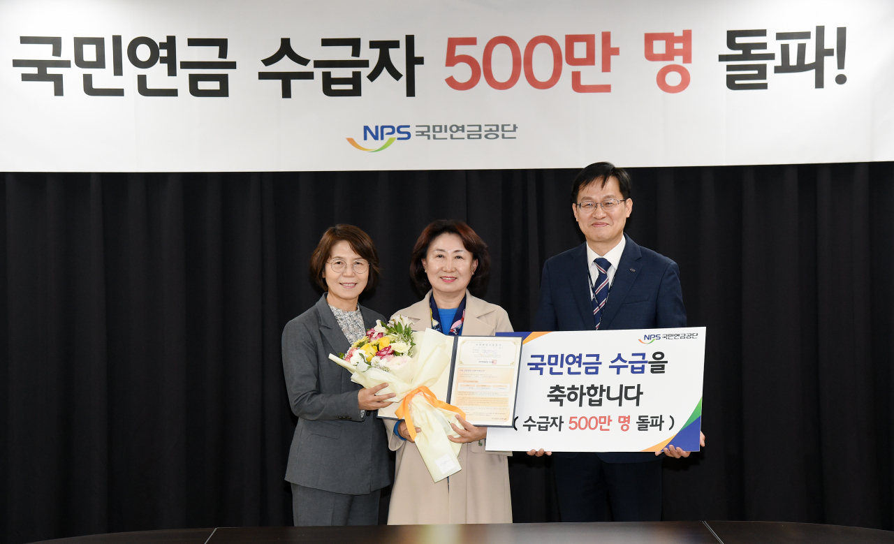 국민연금 500만번째 수급자 명정희씨(가운데)가 기념사진을 찍고 있다. 사진 왼쪽은 강신복 국민연금공단 연금급여실장, 오른쪽은 김정학 국민연금공단 대전지역본부장 [국민연금공단 제공]