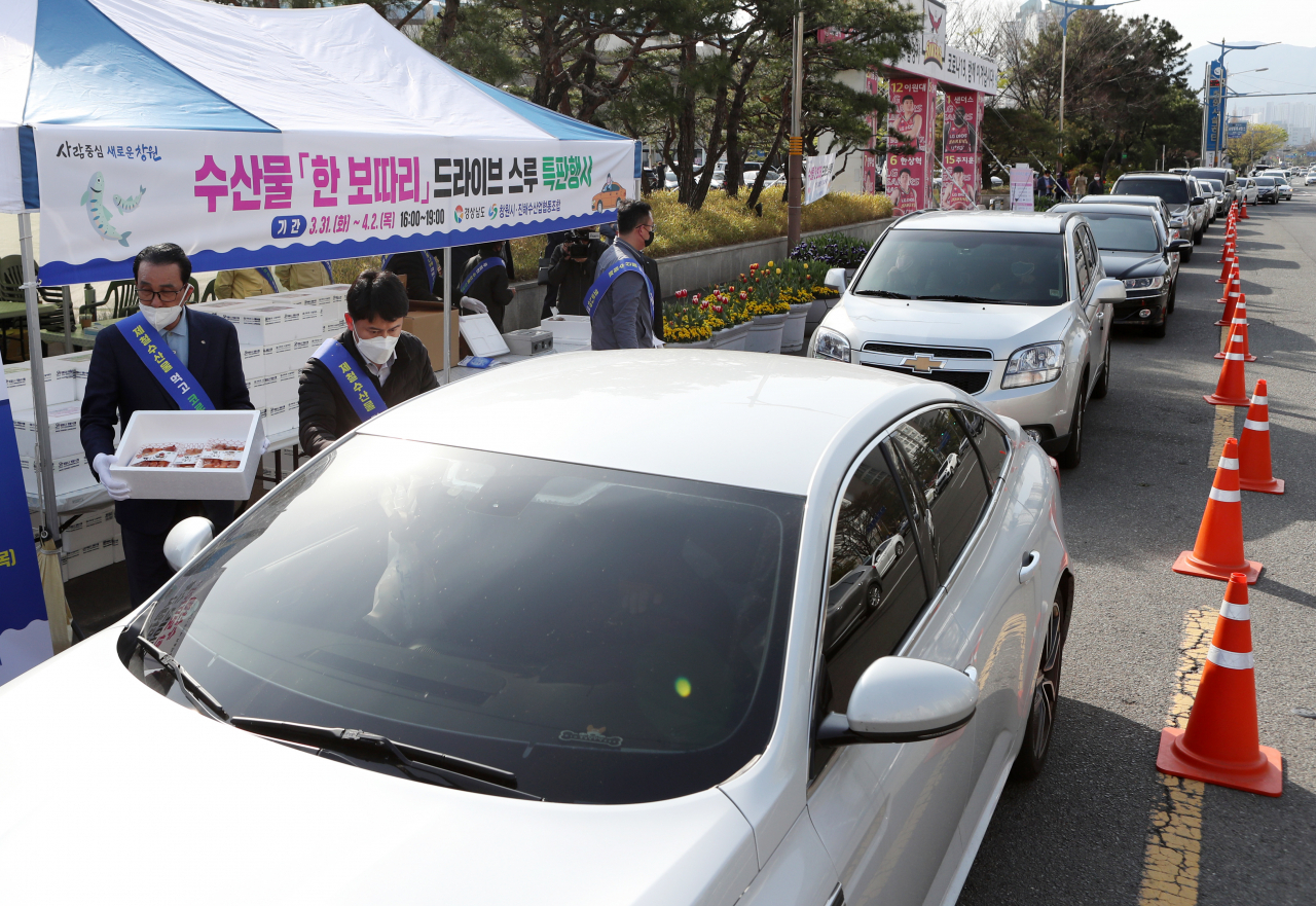 전남 여수시에서 25~26일 드라이브 스루 방식으로 지역 수산물 할인 판매 행사를 연다. 사진은 지난달 31일 창원 스포츠파크 만남의 광장 앞 도로에서 시민들이 차에 탄 채로 수산물을 구매하고 있는 모습. [연합]