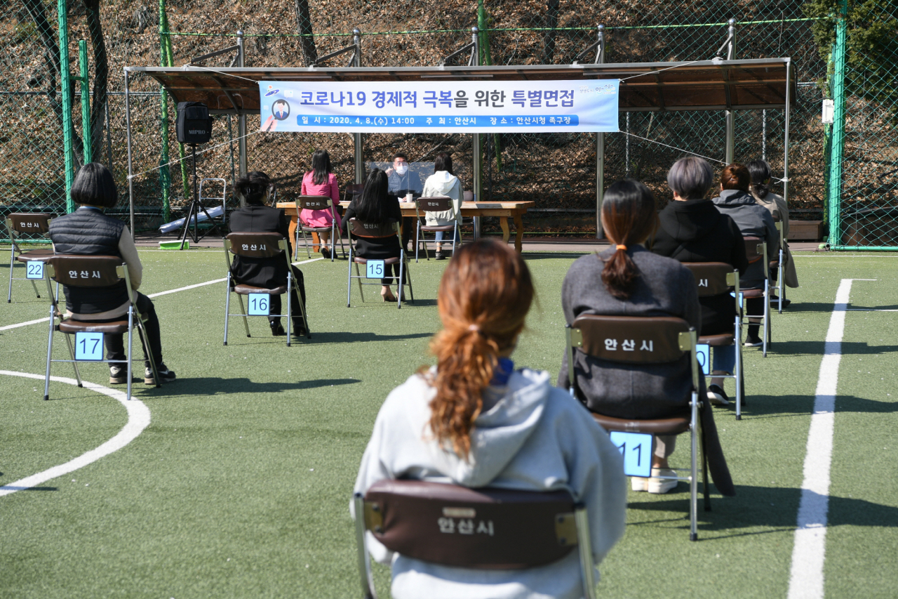 지난 8일 경기도 안산시청 족구장에서 한 업체가 신규 직원 채용을 위한 면접을 진행하고 있다. 코로나19 확산 방지를 위해 야외에서 2m 간격으로 대기석을 마련해 진행되는 모습이다. [연합]