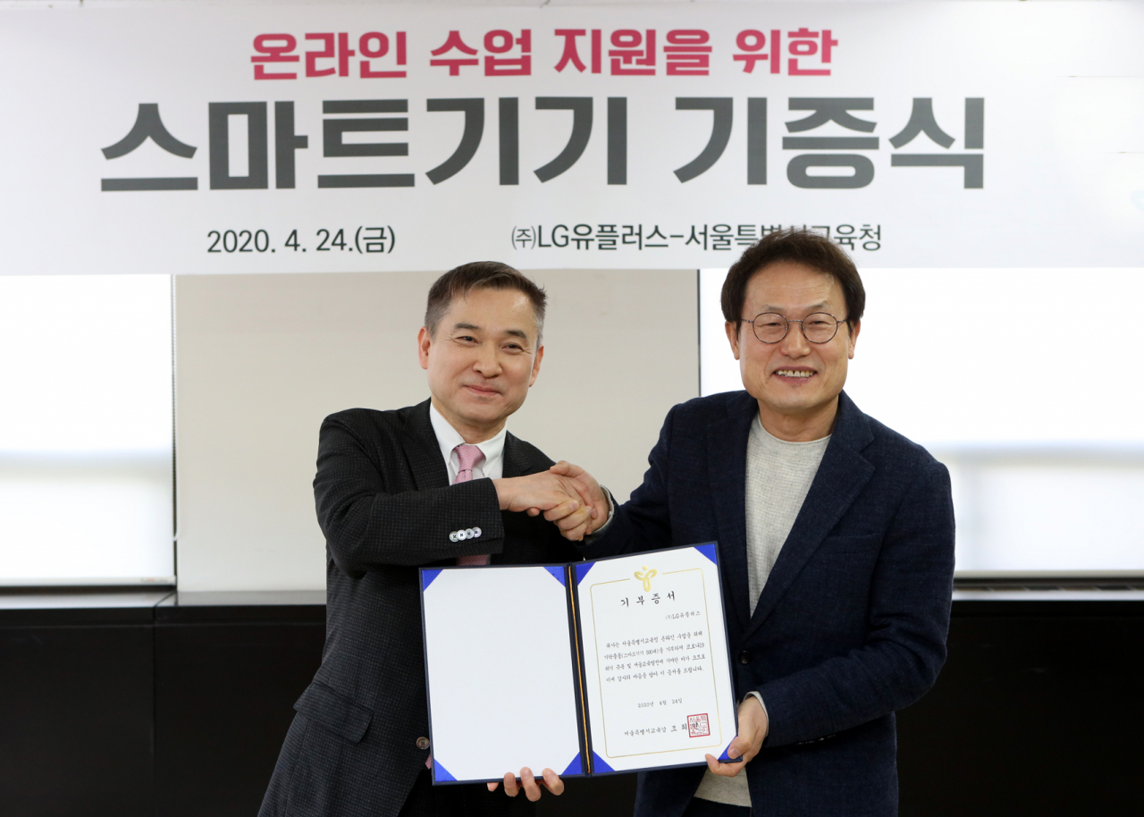 LG유플러스는 24일 종로 서울특별시교육청에서 조희연 교육감, LG유플러스 하현회 부회장 등이 참석한 가운데 교육용 스마트패드 500대 기탁식을 진행했다. 사진은 조희연 서울시교육감(사진 오른쪽)과 하현회 LG유플러스 부회장(왼쪽)이 원활한 온라인 수업을 위한 교육용 스마트패드 기탁식 진행 후 기념촬영을 하고 있는 모습. [LG유플러스 제공]