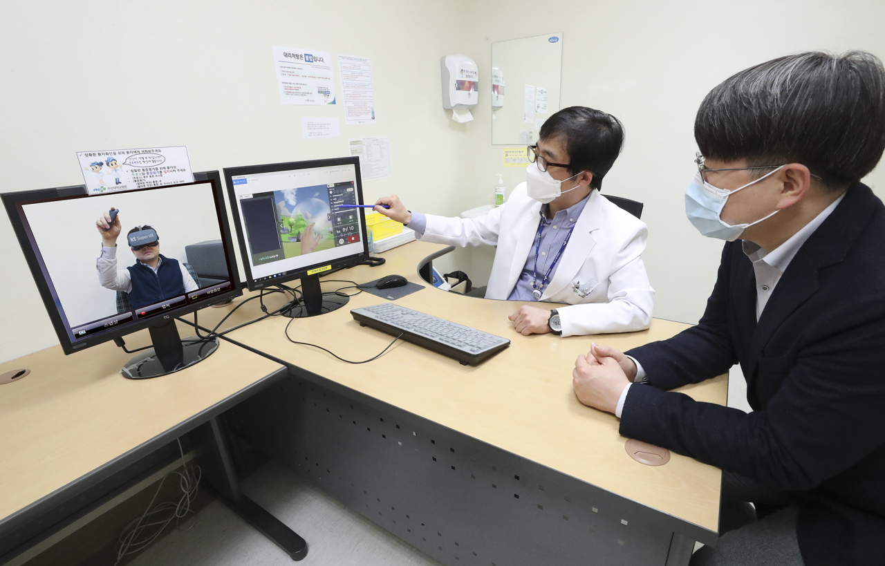 부산대병원 외래 진료실에서 신경과 성상민 교수가 내원 환자에게 슈퍼VR을 통한 재활 훈련을 설명하고 있다. [KT 제공]