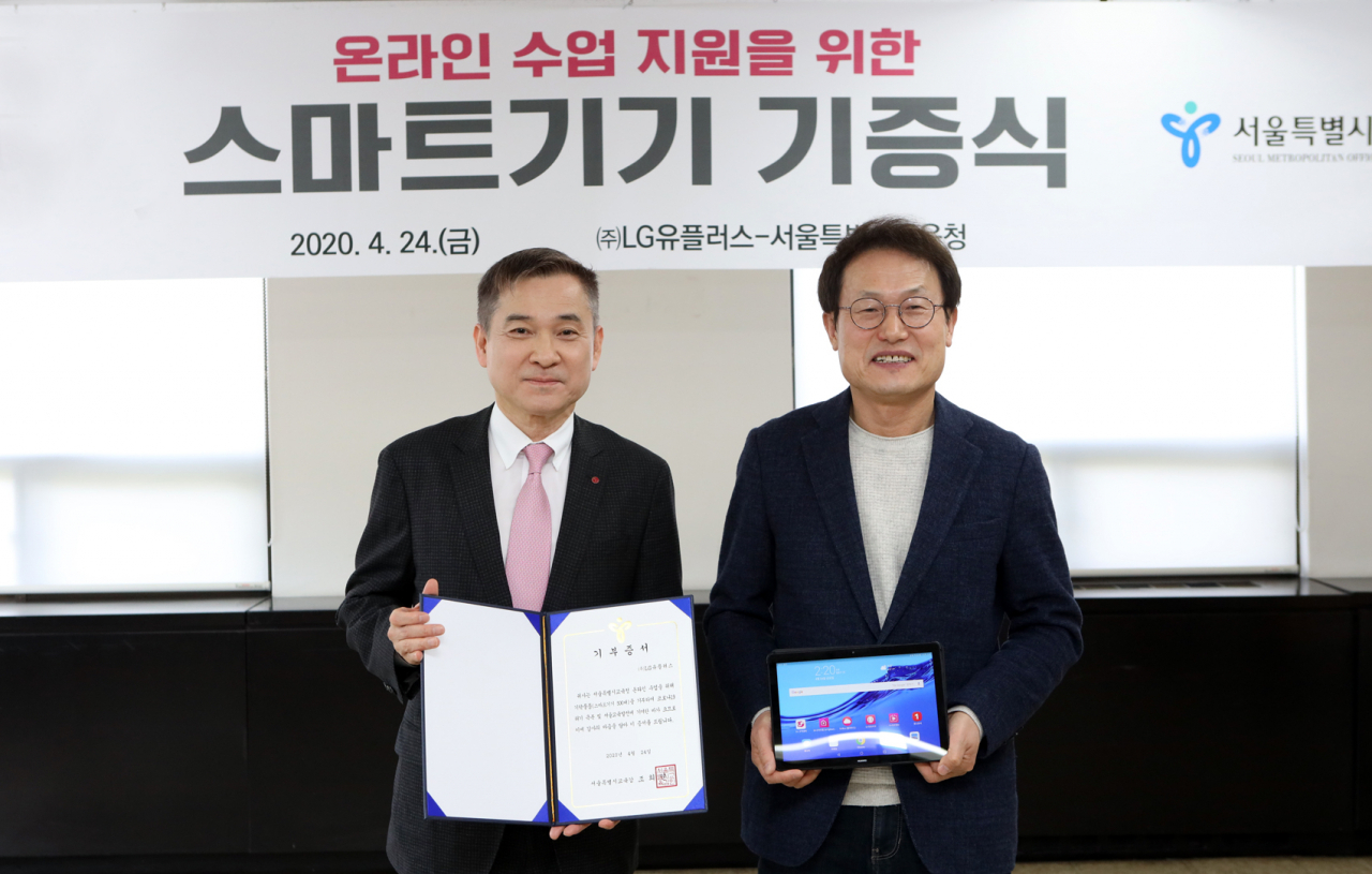 24일 서울 종로 서울특별시교육청에서 조희연(오른쪽) 서울시교육감과 하현회 LG유플러스 부회장(왼쪽)이 원활한 온라인 수업을 위한 교육용 스마트패드 기탁식 진행 후 기념촬영을 하고 있다. [LG유플러스 제공]
