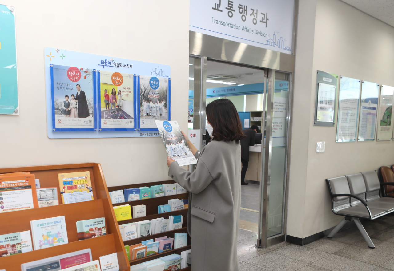 한 민원인이 영등포구청 별관에 있는 ‘탁트인 영등포’ 소식지 비치대에서 소식지 4월호를 살펴보고 있다. [영등포구 제공]