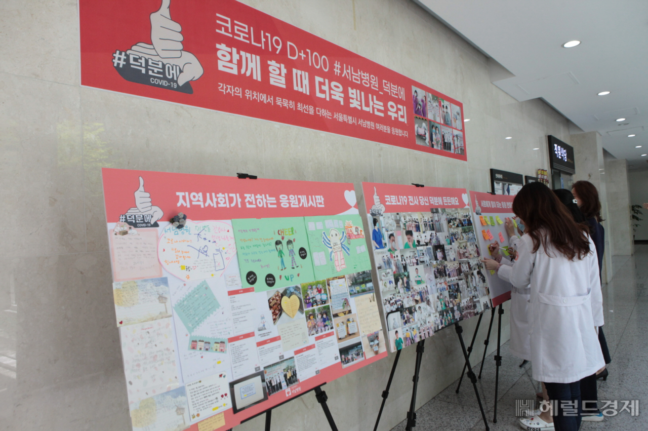 서남병원 구내식당 옆에 마련된 응원 게시판을 의료진들이 들여다보고 있다. [서남병원 제공]