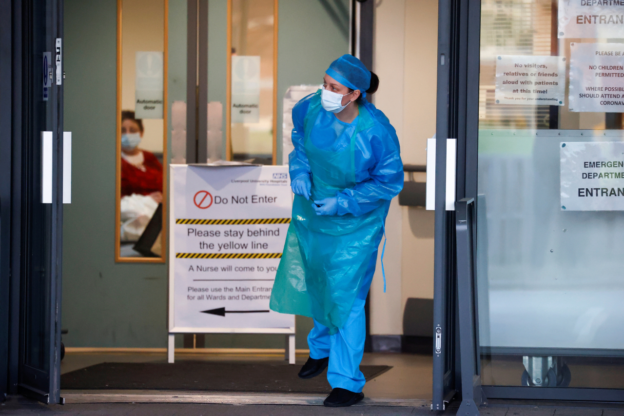 지난 23일(현지시간) 영국 리버풀의 한 대학병원에서 국민보건서비스(NHS) 소속 직원이 병원 문 밖을 바라보고 있다. [로이터]