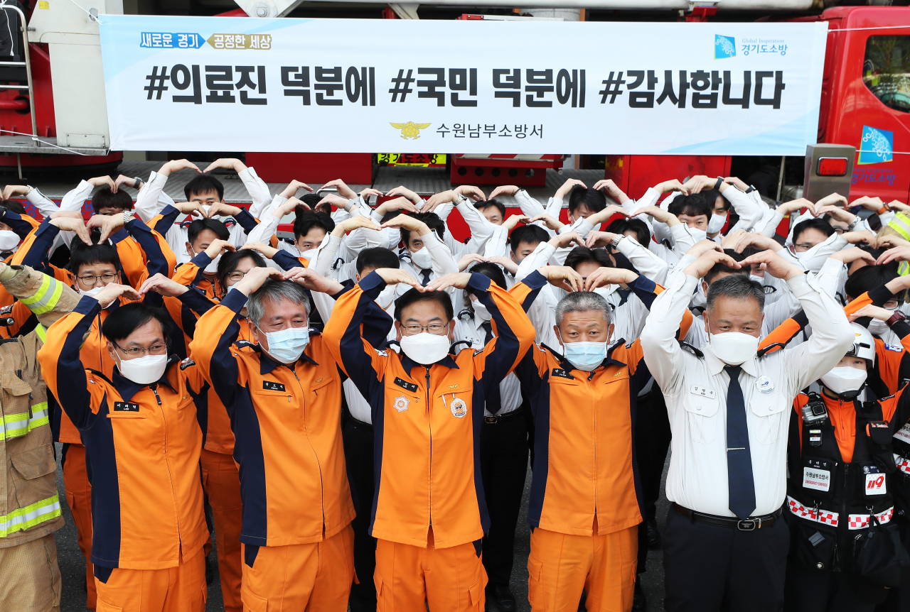 29일 오전 경기도 수원남부소방서에서 이정래 서장을 비롯한 소방관들이 신종 코로나바이러스 감염증(코로나19) 환자 진료와 치료에 힘쓰는 의료진들을 응원하는 '덕분에 챌린지' 캠페인을 하고 있다. 연합뉴스