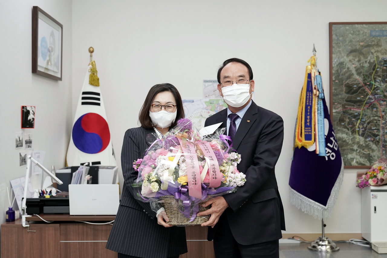은수미 성남시장(왼쪽)이 ‘플라워 버킷 챌린지’ 다음 주자로 지목한 박용후 성남상공회의소 회장에게 꽃다발을 전하고 있다. [성남시 제공]