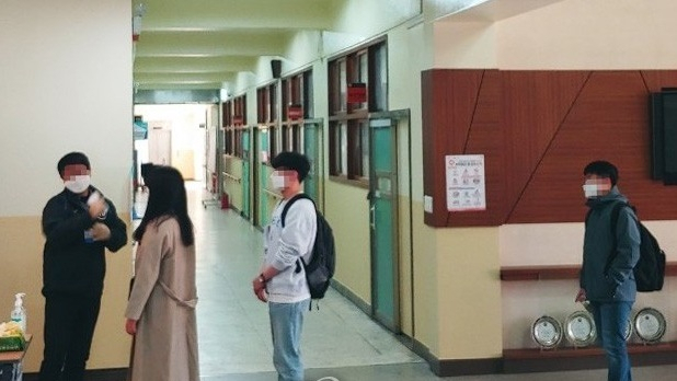지난달 26일 서울 중구의 한 중학교에서 토익 시험 응시생들이 마스크를 착용한 채 고사장 입장을 위해 발열 검사를 받고 있다. [연합]