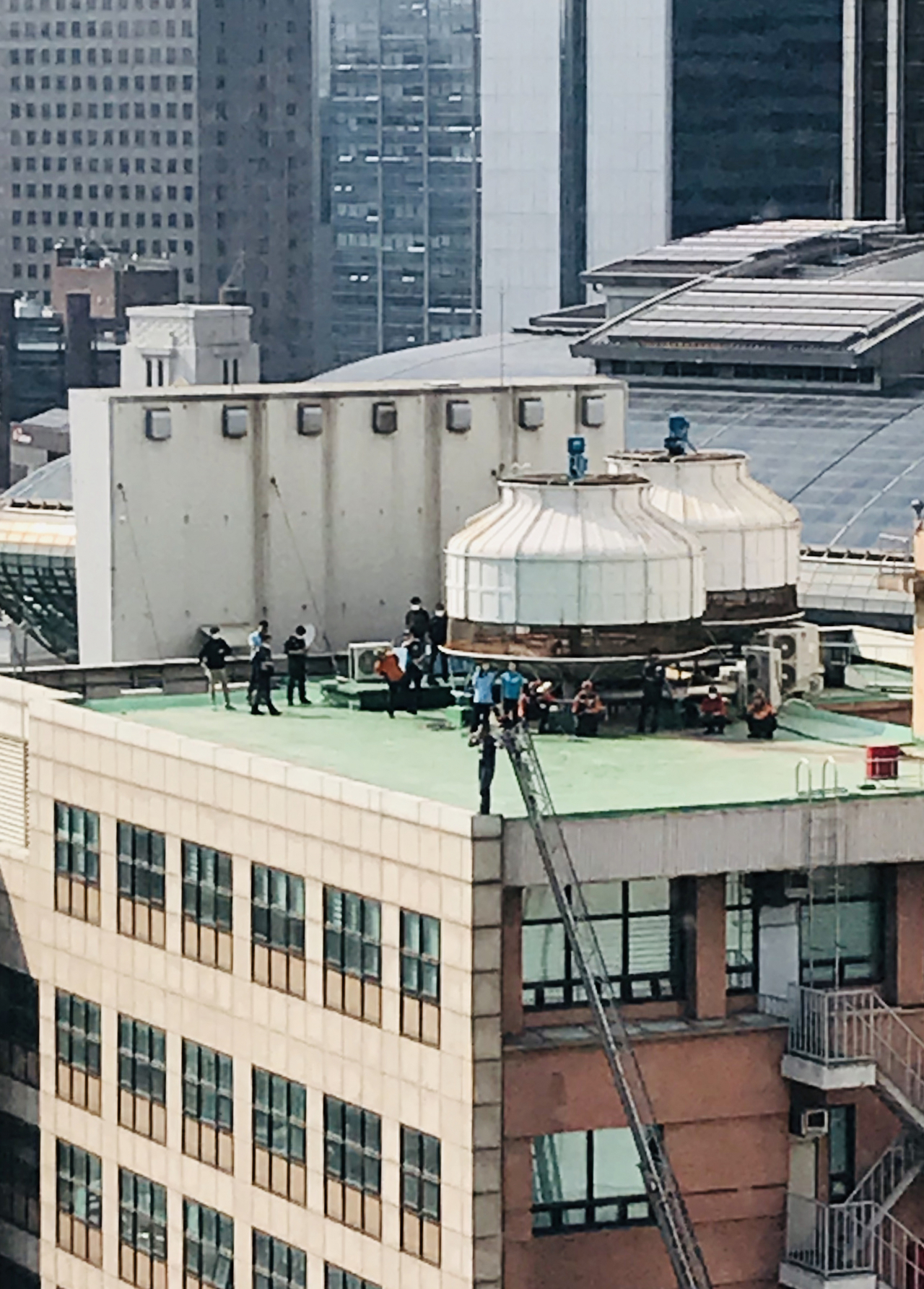 1일 오후 2시께 서울 중구에 있는 14층짜리 재능교육빌딩 옥상 난간에 40대로 추정되는 남성이 위험한 상태로 있다는 신고가 경찰에 접수됐다. 사진은 재능교육빌딩 옥상에서 남성이 소동을 벌이는 모습. [연합]