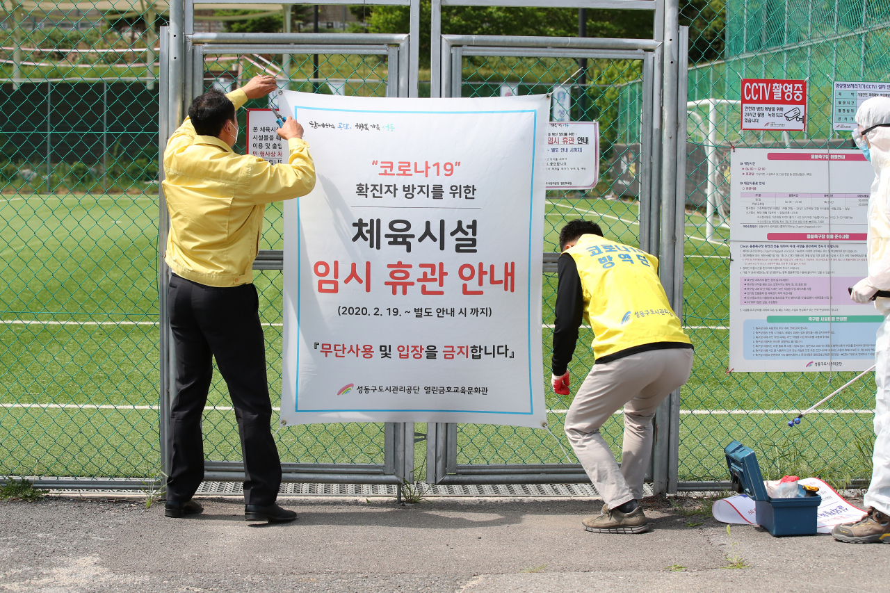4일 오후 서울 성동구 응봉축구장에서 성동구청 관계자들이 경기장 방역을 위해 임시 휴관 안내문을 철거하고 있다. 정부의 생활 속 거리두기 지침에 따라 6일부터 응봉축구장 운영을 다시 시행한다. 연합뉴스
