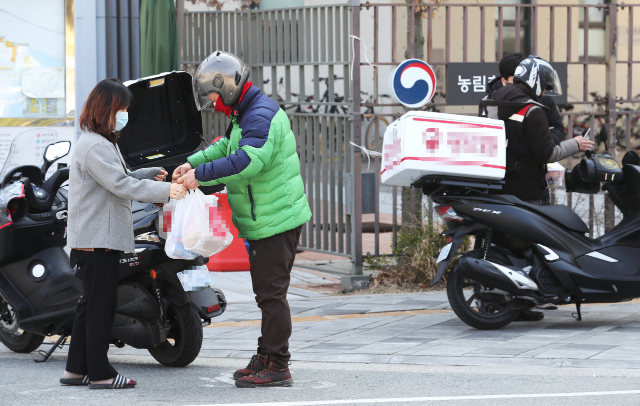 세종시 정부세종청사 해양수산부 앞에서 공무원들이 배달시킨 도시락을 찾고 있다. [사진제공=연합뉴스]