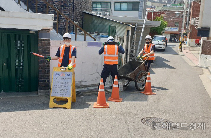 구로구청 직원들이 주택가 빗물받이에 쌓여 있는 이물질들을 청소하고 있다. [구로구 제공]