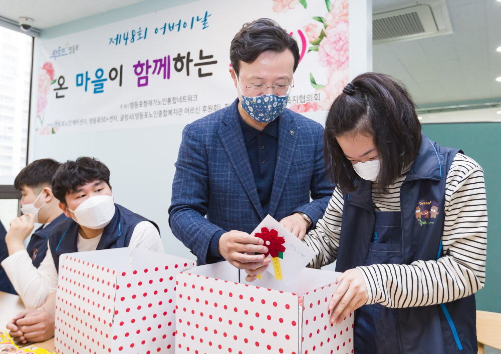 채현일 영등포구청장이 ‘효 한상’ 키트에 카네이션과 함께 손 편지를 넣고 있다. [영등포구 제공]