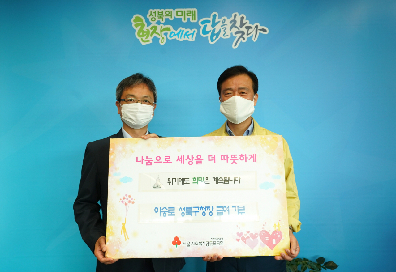 지난 6일 이승로(오른쪽) 성북구청장이 4개월치 급여 30%를 서울시사회복지공동모금회에 기부하고 김용희 사무처장과 기념촬영을 하고 있다. [성북구 제공]