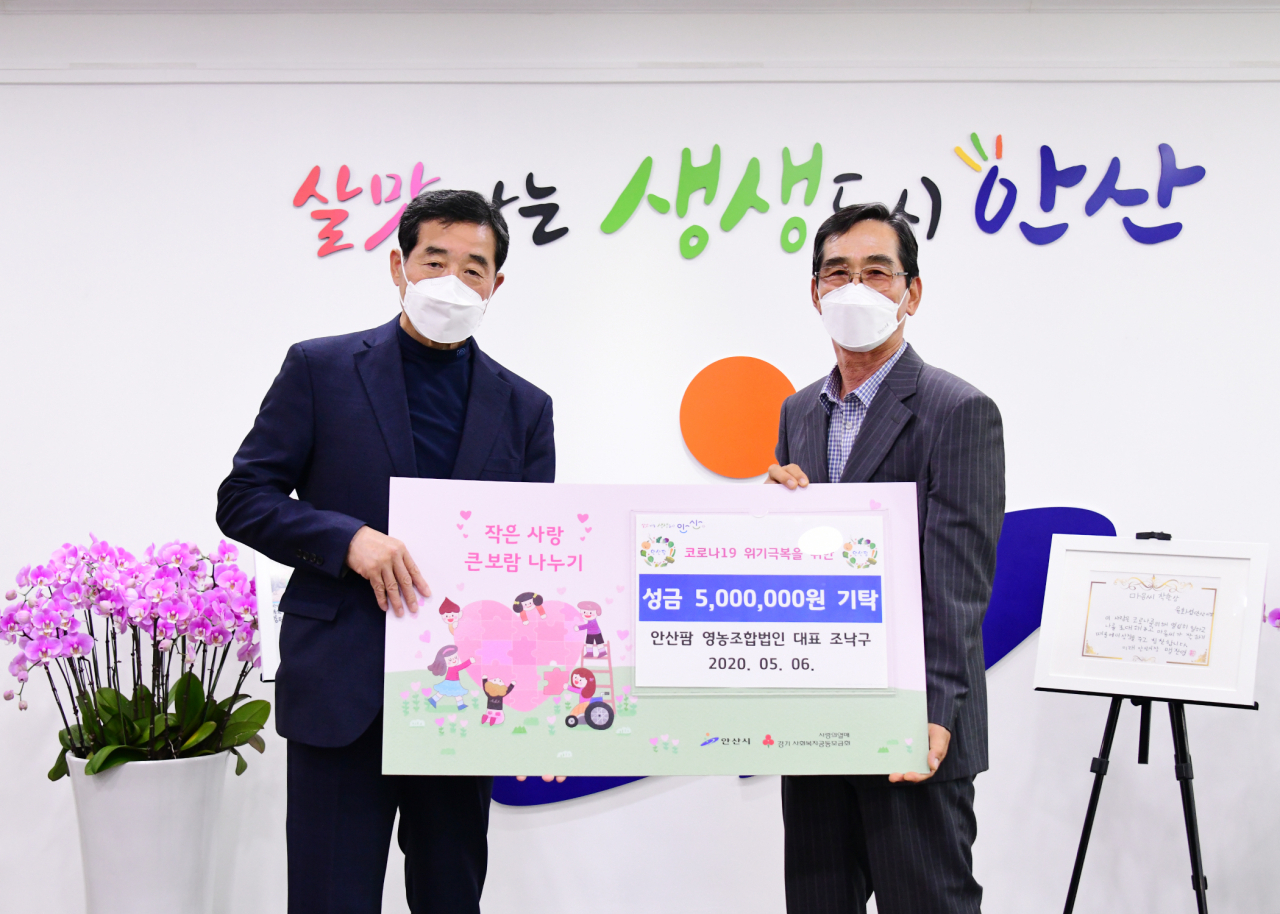 윤화섭 안산시장이 지난 6일 시장실에서 열린 기탁식에서 조낙구 안산팜 영농조합법인 대표와 기념촬영을 하고 있다. [안산시 제공]